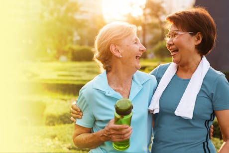 Two women laughing as they stay active to help prevent heart disease.